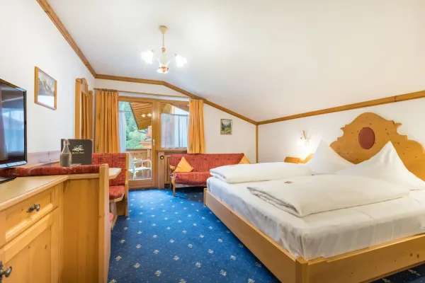 Landhaus Zimmer - Blick auf das Doppelbett, TV und Balkon