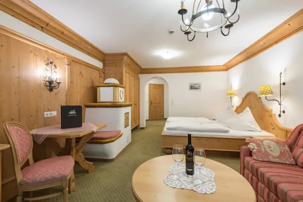 Turm Suite - Blick in die Suite auf Kachelofen, Couch und Bett