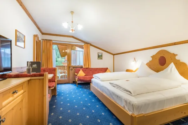 Landhaus Zimmer - Blick auf das Doppelbett, TV und Balkon